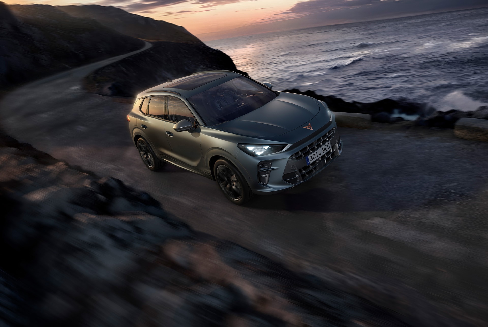 Front side view of a new cupra terramar driving along a rural coastal road