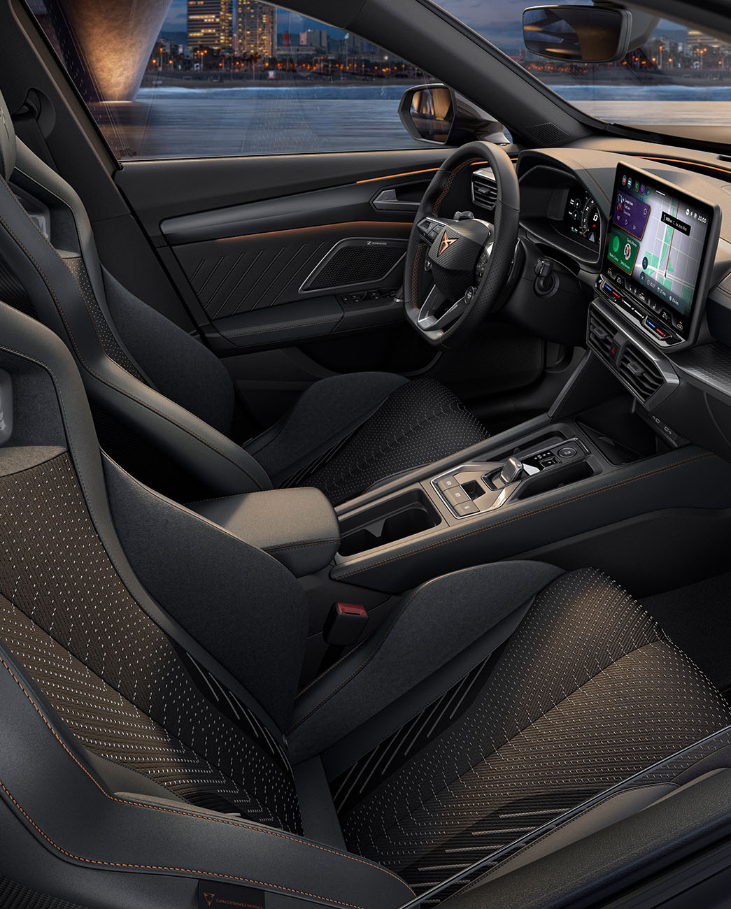 Interior view of the new CUPRA Formentor’s cockpit features black bucket seats with copper accents and stitching, complemented by an advanced infotainment system and a steering wheel featuring the CUPRA logo.