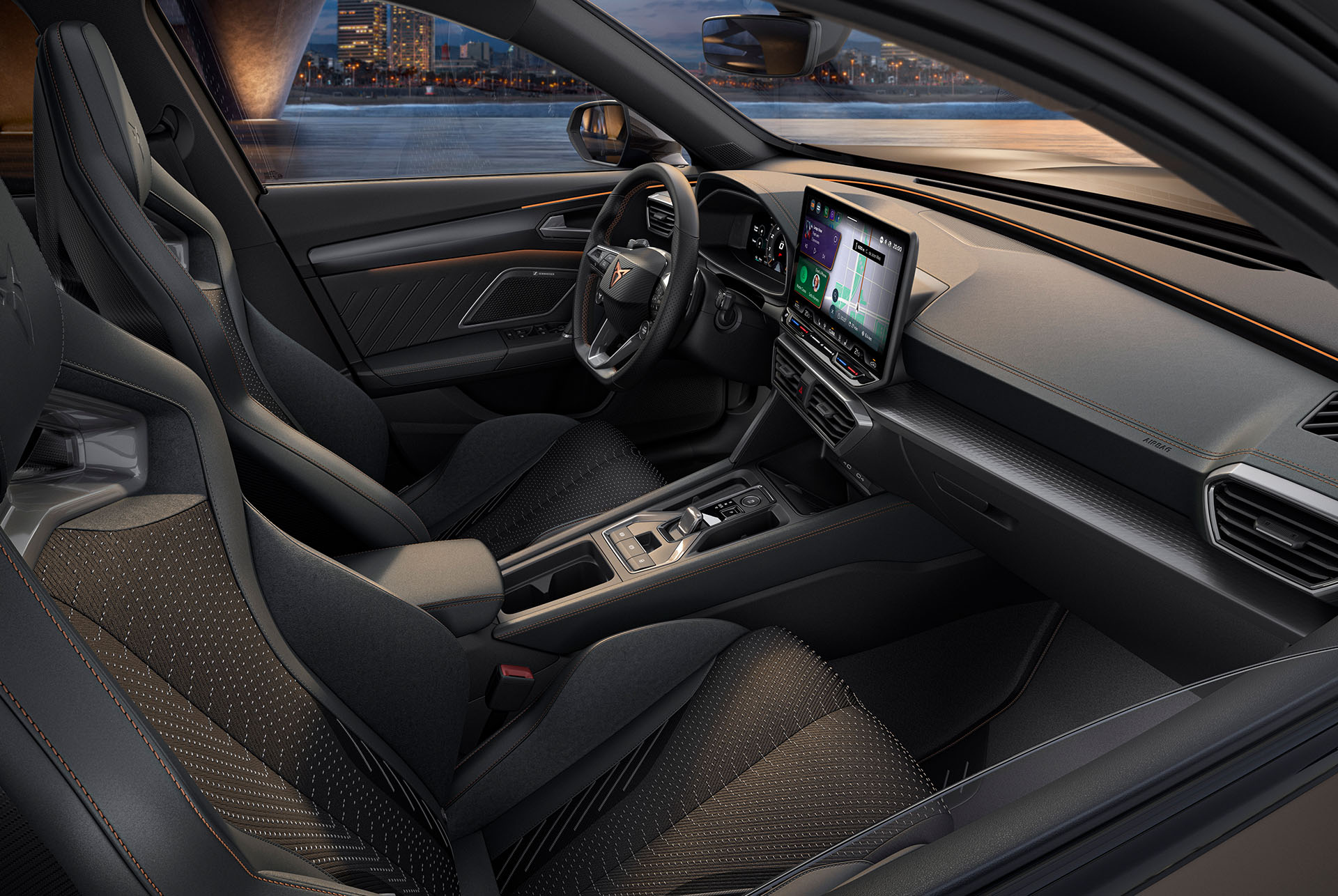 Interior view of a new CUPRA Formentor interior with sporty seats, detailed stitching, a multifunctional steering wheel, large infotainment screens and a sleek dashboard design. The car overlooks a cityscape at dusk through the windshield.