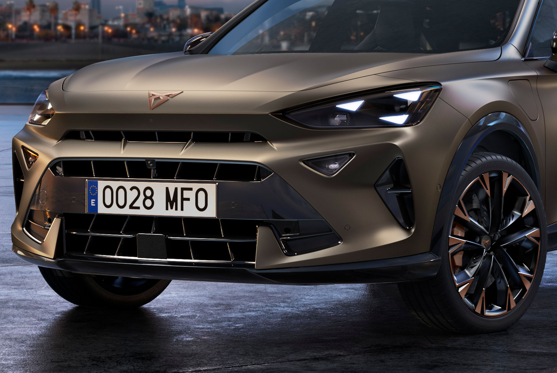 Close up of the front of a new century bronze CUPRA Formentor SUV Coupé with copper accent wheels, signature triangle eye front lights and distinctive CUPRA logo.